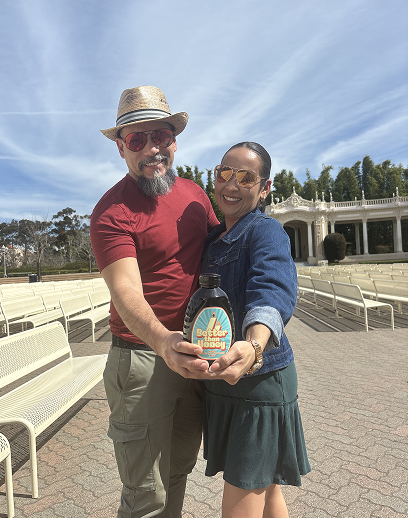 Happy customers holding Better Than Honey molasses bottle outdoors