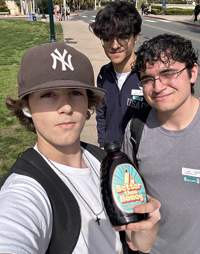 Young customers holding Better Than Honey molasses bottle outdoors