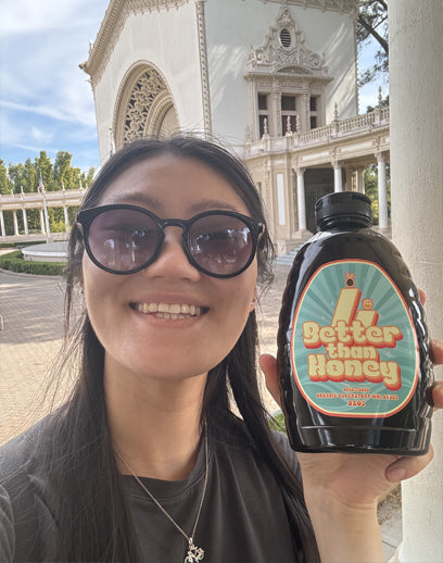 Smiling women holding Better Than Honey blackstrap molasses bottle